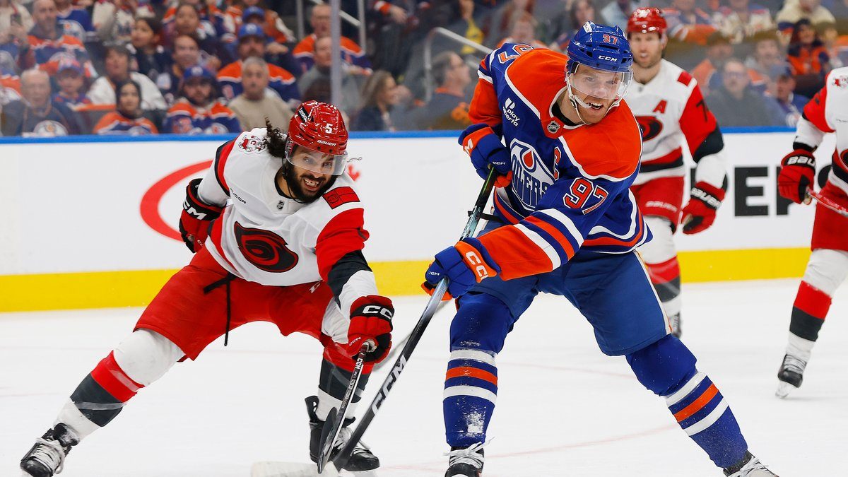 Connor McDavid (Edmonton Oilers) laukoo Carolinan Jalen Chatfieldin edestä Edmontonin kotiottelussa
